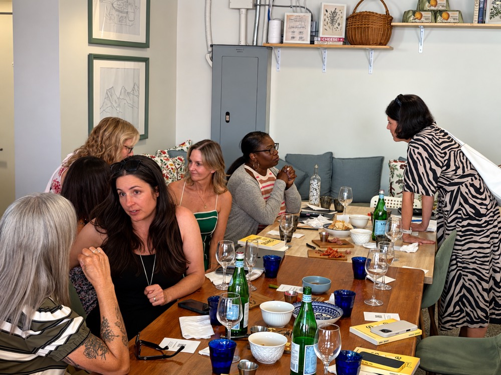 Attendees in conversation around the table at Bubbles and Bots Vol. 2